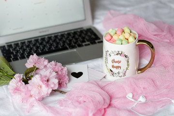 Home desk with laptop, headphones and cup of coffee with marshmallows. Business concept