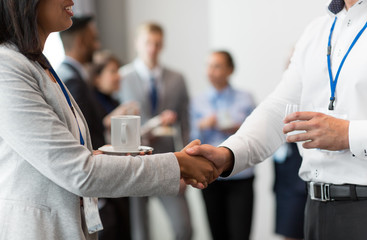 business, partnership and cooperation concept - handshake of people at international conference