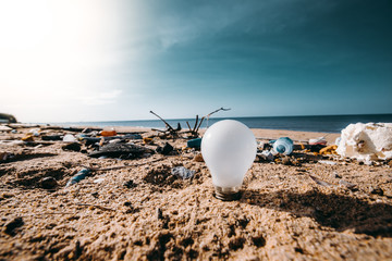 Light blub, glass bottles and garbage waste on the beach