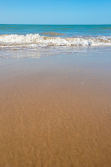 Fototapeta na wymiar oft wave of blue ocean on sandy beach. Copy space for text