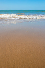 oft wave of blue ocean on sandy beach. Copy space for text