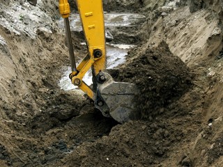  Photo of the bucket of the excavator digging the pit.