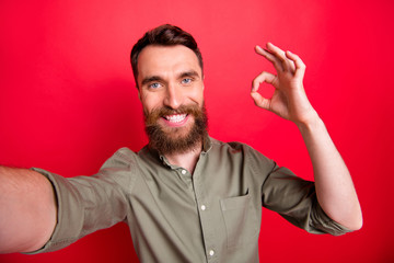 Self portrait of man wearing grey shirt showing you ok sign in order to advise you something he is...