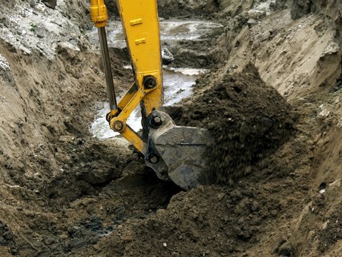 Photo of the bucket of the excavator digging the pit.