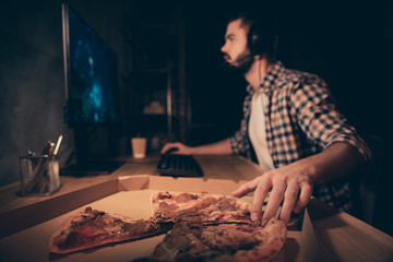 Close up side profile view photo he him his guy videogame talk headset microphone teammates concentrated look screen hand arm take pizza slice wear casual plaid checkered shirt cafe table indoors