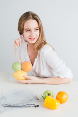 Girl packs the vegetables and fruits in a reusable cloth bag