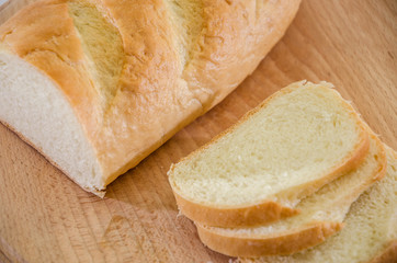 Long loaf on a wooden board. Close-up. Delicious Ukrainian bread. Sliced bread.