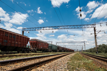 Obraz premium Industrial railway - wagons, rails and infrastructure, electric power supply, Cargo transportation and shipping concept.