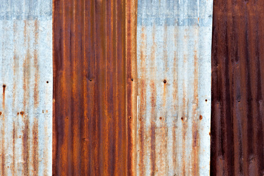 Close up of rusty corrugated iron metal sheet texture. Picture with grain and color from film simulation filter.
