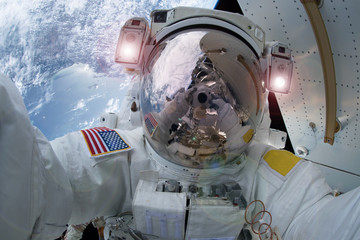 The astronaut in a space suit, does selfie, in an outer space, at the space station.  Elements of this image were furnished by NASA © Artsiom P