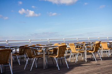 Outdoor tables and chairs on Cromer pier on a bright day