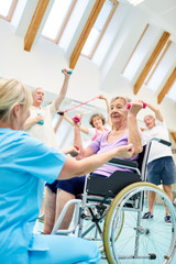 Seniorin im Rollstuhl in der Fitness Gruppe