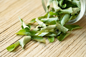 dried curry tree leaves on the wooden board