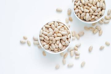 White kidney bean in white ceramic bowl on white background.