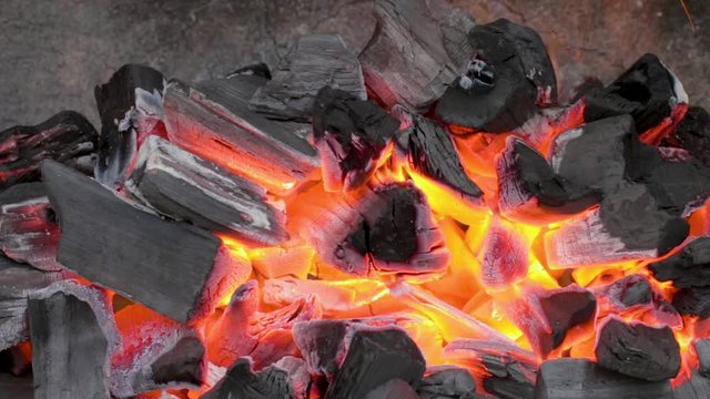 Charbon de bois br&ucirc;lant dans un barbecue en pierre