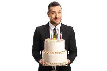 Handsome elegant man in a suit holding a cake with candles