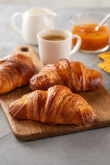 Freshly baked croissants and coffee cup on grey table. Copy space.