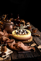 Beautiful still life with homemade delicious three chocolates cheese cake on wooden stand on rustic table