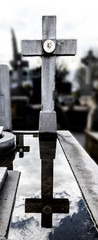 reflection of a cross in the puddle of a grave