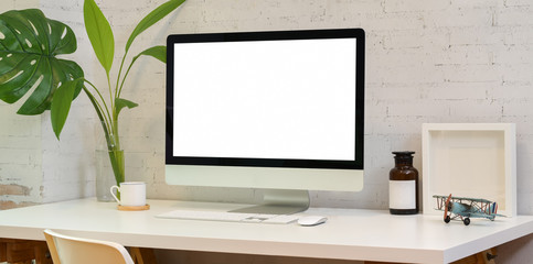 Stylish workplace with blank screen desktop computer