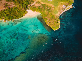 Tropical ocean with beach and surfers in Bali, drone shot. Aerial view.