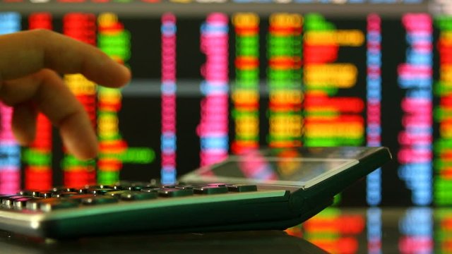 Calculator  with stock exchange board background , in studio Chiangmai Thailand