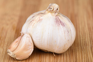 Head of garlic and cloves of unpeeled garlic on a wooden background.