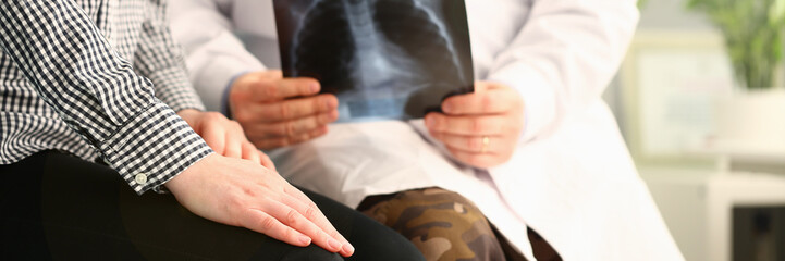 Fototapeta na wymiar Doctor holds patient x-ray and reports bad news