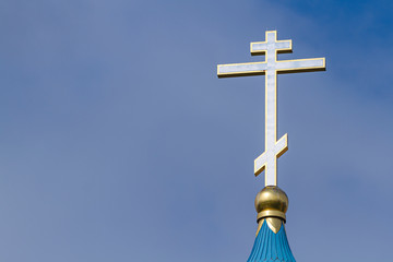 The dome of the Orthodox Church with a golden cross against the sky.