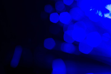 Blue bokeh lights on dark background; abstract background