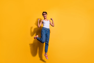 Fototapeta na wymiar Full length body size photo beautiful she her dark skin excited lady jumping high yell yeah yes triumphant champion wear casual jeans denim pants trousers tank-top isolated bright yellow background
