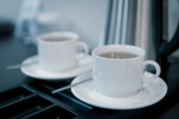 two white ceramic cups with green tea