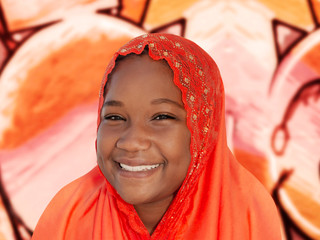 Portrait of a smiling girl wearing an embroidered headscarf  (ten years old child)