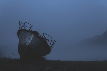 old boat washed ashore in fog