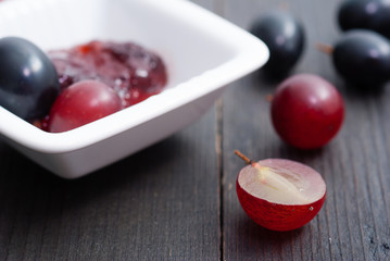 grape jelly and red grapes on black wood table