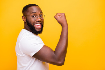 Dark skin guy celebrating lottery winning raising fist up wear casual outfit isolated yellow...