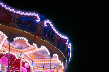 Children's Carousel at an amusement park in the evening and night illumination. Amusement...