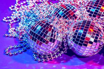 Shiny small disco balls sparkling in a beautiful purple light. Disco party concept