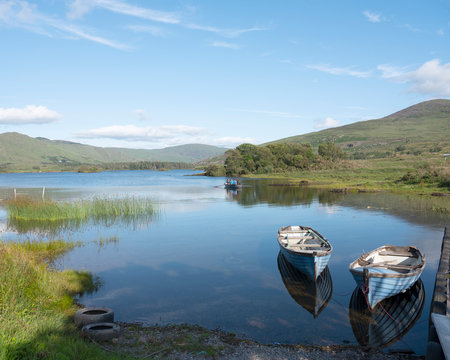 boats on lake cloonee lough on beara peninsula in ireland