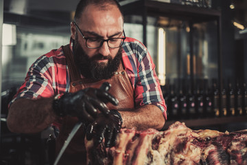 Obraz premium Chef cutting beef carcass in a restaurant