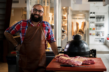 Cheefrul chef with raw beef steakes in a restaurant