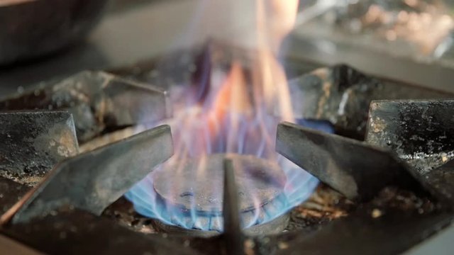 Lightining gas cooking stove, person turns on kitchen cooktop gas 