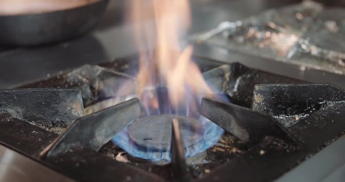 Lightining gas cooking stove, person turns on kitchen cooktop gas 