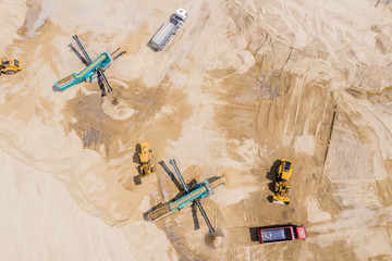 Aerial view of sand quarry with trucks and bulldozers. Heavy bulldozer loading  sand,