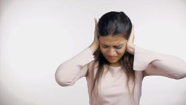 Fearless Indian woman fighting against domestic violence with bruises on her face. Traumatized young girl saying no to sexual abuse while showing stop gesture against white background - stop abusin...