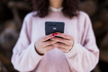 Unrecognizable young woman in the forest using with mobile phone. Outdoors and lifestyle