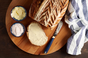 Artisan sourdough sliced toast bread with butter and pink himalayan salt on cutting board