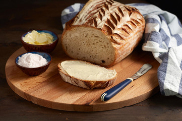 Artisan sourdough sliced toast bread with butter and pink himalayan salt on cutting board