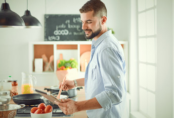 Smiling and confident chef standing in large kitchen