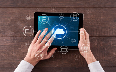 Hand touching tablet with cloud computing and online storage concept